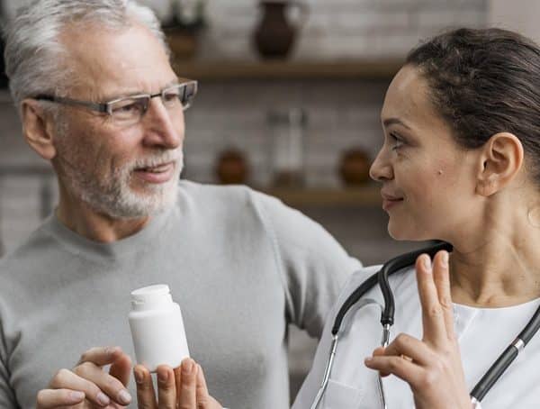 Nurse holding pill container showing person and indicating dosage - picture for Medication Management training course